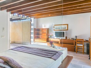Une chambre à coucher moderne avec un grand lit, un bureau et un téléviseur.