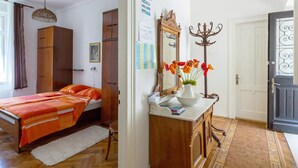 A bedroom with a bed, wooden wardrobe, and a mirror with a vase of flowers. - Apartments Marija, (12033), Dubrovnik, hr (Dubrovnik)