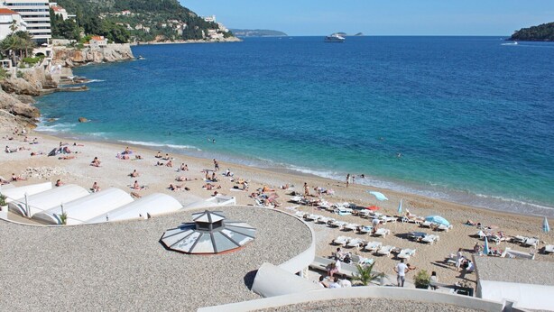 A beach with sun loungers, umbrellas, and a view of the sea. - Apartments Marija, (12033), Dubrovnik, hr (Dubrovnik)