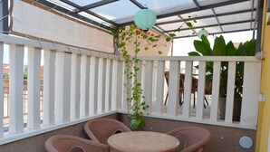A covered patio with wicker furniture, a round table, and a white picket fence. - Apartments Damnjanka, (12453), Orebić, hr (Orebi�����)