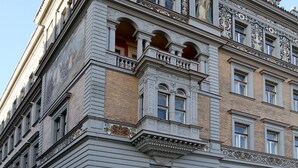 Un edificio histórico con arquitectura clásica, que presenta balcones ornamentados y fachadas detalladas.