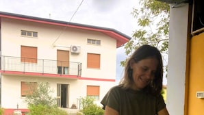 A person cutting bread on a table with a pizza box and bread in the background. - A genuine stay in Friuli... (Grions)