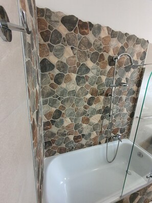 Tina con regadera, secadora de cabello, bidet, toallas 