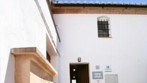 A courtyard with a fountain, a white building with a door, and a small window. - Casas Rurales Los Arrayanes for 4 people (Ronda)