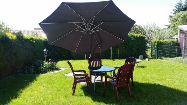A patio with a table and chairs under a large umbrella.