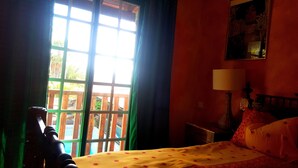 A room with a bed, a nightstand, a lamp, and a window with curtains. - Tropical finca, sea view, mountain panorama, sandy beach 5 minutes (Arico)