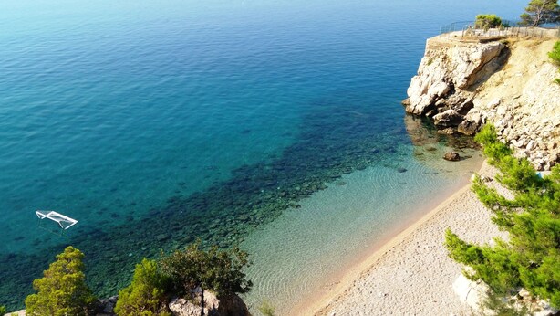 A clear view of a beach with rocky cliffs and a boat in the water. - Private oasis for up to 6 adults with swimming pool, sea view & 2 beaches nearby (Marušići)