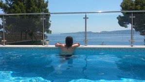 A person relaxing in a pool with a view of the sea and mountains. - Private oasis for up to 6 adults with swimming pool, sea view & 2 beaches nearby (Marušići)