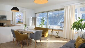 Eine moderne Küche mit Essbereich, Holzboden und einem großen Fenster mit Jalousien.