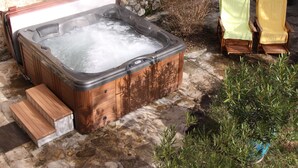 A hot tub with wooden steps and a stone wall in the background. - La Farigoule for 6 persons rental with shared pool nature and calm (Flayosc)