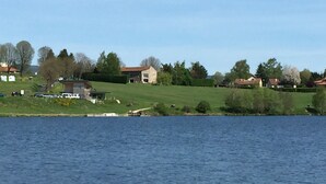 Vista de un lago con casas y vegetación.