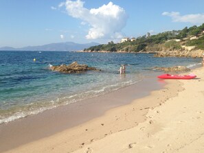 A beach with clear water, a red kayak, and footprints in the sand. - ENTIRE VILLA, 160 m2, 700 m from the ocean, ocean view, the Bloody Islands, and scrubland. (coti chivari)