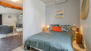 Une chambre à coucher comprenant un lit, des tables de chevet, un bureau, une chaise et un téléviseur.