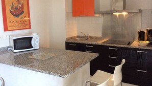 A modern kitchen with granite countertops, a microwave, a sink, and a stove.