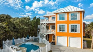 A two-story house with a swimming pool, white picket fence, and a garage. - Dreamsicle: Pool, Pup & Family Fun (Emerald Isle)