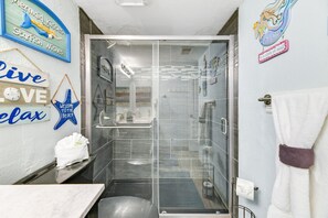 Een bad/douchecombinatie, een haardroger, handdoeken