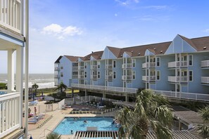 Un hotel con piscina, balcones y vista al océano.