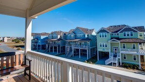 A coastal residential area with multiple two-story houses featuring balconies and waterfront access. - 5547- Sailfish Station - Nags Head Luxury Home Private Pool OBX (Nags Head)