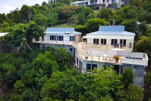 A hillside house with a balcony and a patio area.