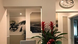 Un bureau en bois avec un ordinateur portable et une plante en pot décorée d’un ruban rouge.