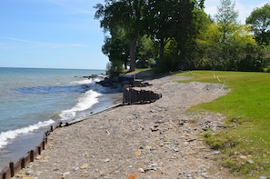 Enjoy a serene lakeside retreat with a pebble-strewn beach and grassy area.