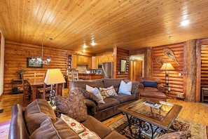 L’intérieur d’un chalet confortable, avec un salon, un coin repas et une cuisine.