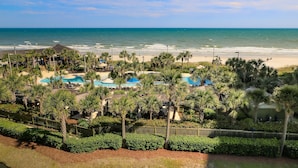 A resort with a pool area, palm trees, and a view of the ocean. - Royale Palms, 3rd floor,  Rare Amazing Direct Ocean Front View (Myrtle Beach)