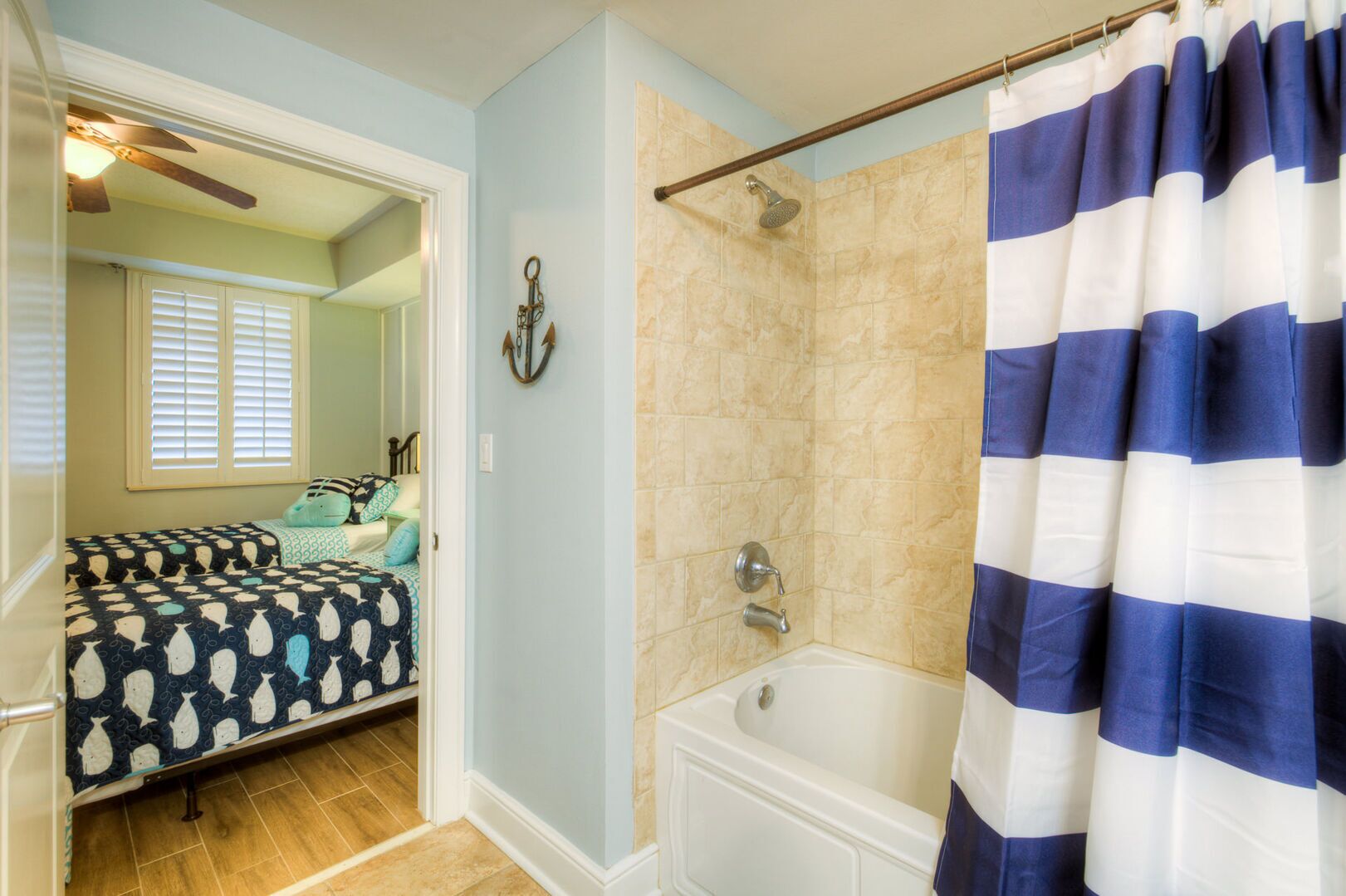 A bathroom with a bathtub, shower, and a striped shower curtain.