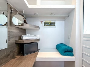 A compact bathroom with a mirror, towel rack, shelf, and a small heater. - 1BR with balcony (Isla Mujeres)