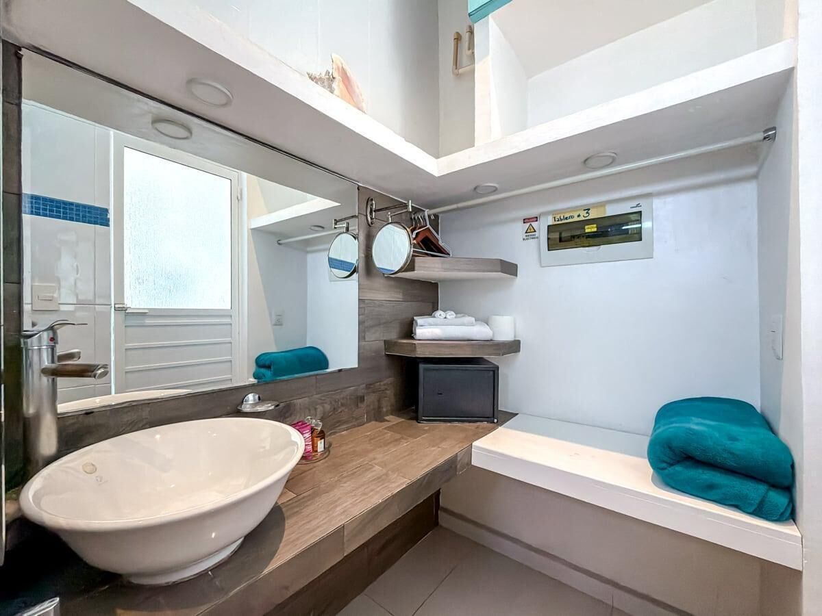Une salle de bain moderne avec un grand lavabo, un miroir et un porte-serviettes.