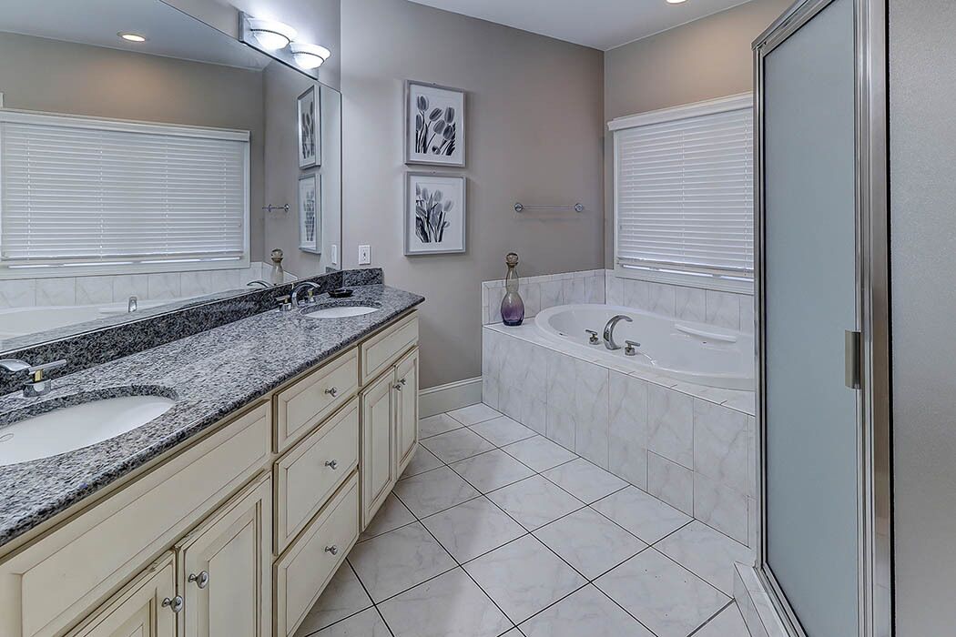A bathroom with two sinks, a bathtub, and a shower.