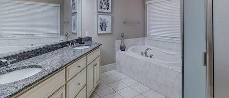 A bathroom with two sinks, a bathtub, and a shower.