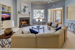 A living room with a fireplace, a sofa, a coffee table, and a television.