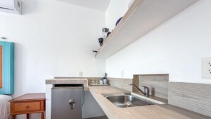 A compact kitchen with a refrigerator, sink, and wooden countertop. - Beautiful 1BR studio just steps from downtown (Isla Mujeres)