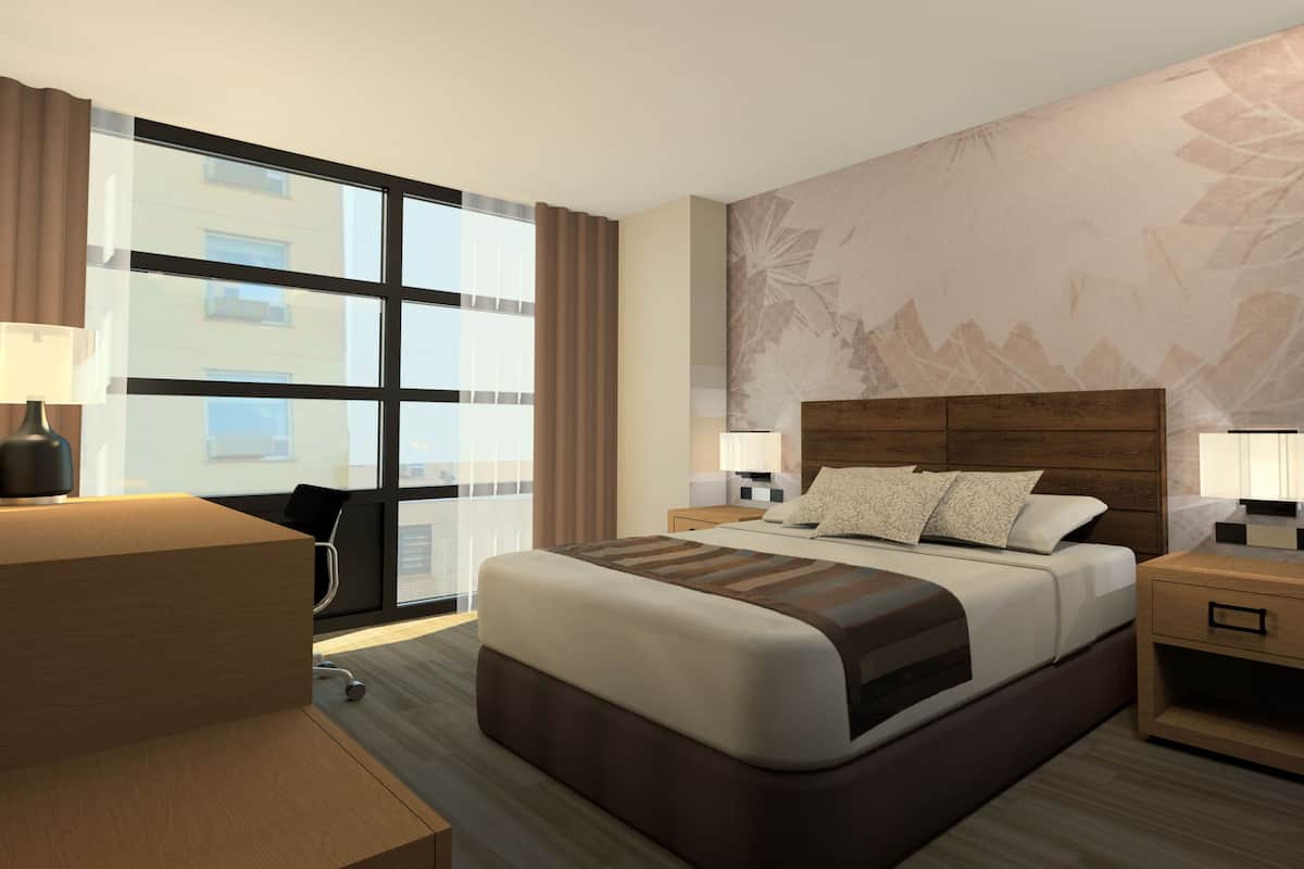 Une chambre d’hôtel moderne, dotée d’un grand lit, de tables de chevet, d’un bureau et offrant une vue sur la ville.