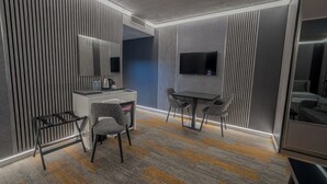A modern hotel room with a desk, two chairs, a flat-screen TV, and a large mirror. - Tryp By Wyndham Istanbul Sancaktepe (Istanbul)