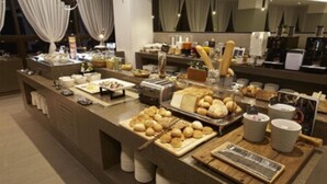 A buffet setup with various food items and a coffee station. - Ramada Hotel & Suites by Wyndham Gangwon Pyeongchang (Pyeongchang)
