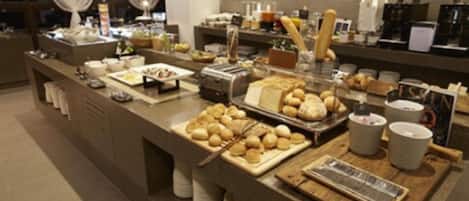 A buffet setup with various food items and a coffee station.