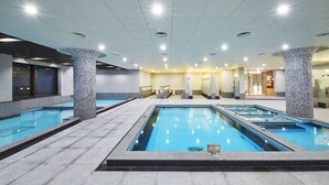 A swimming pool area with multiple pools, tiled flooring, and ceiling lights. - Ramada Hotel & Suites by Wyndham Gangwon Pyeongchang (Pyeongchang)