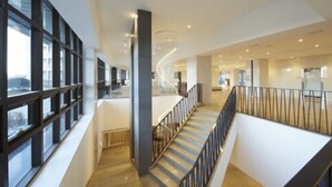 A modern interior with a staircase, large windows, and a high ceiling. - Ramada Hotel & Suites by Wyndham Gangwon Pyeongchang (Pyeongchang)