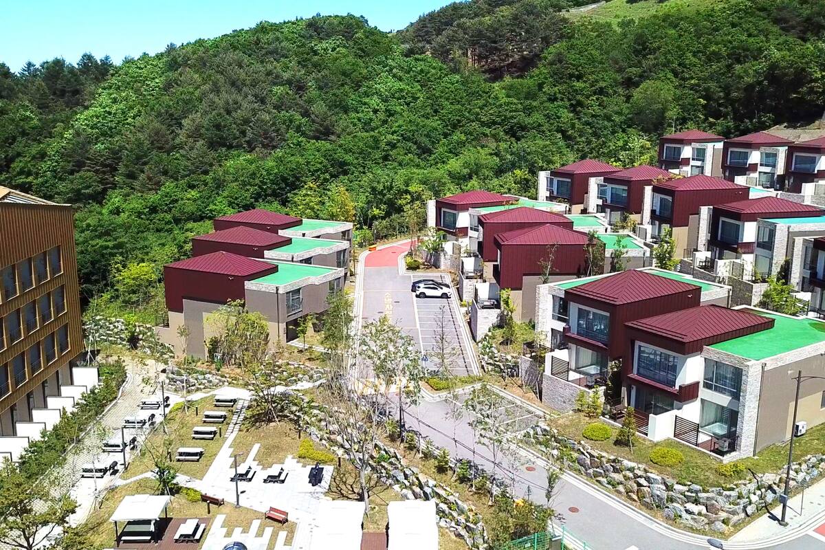 A residential area with modern houses, a parking lot, and a road.