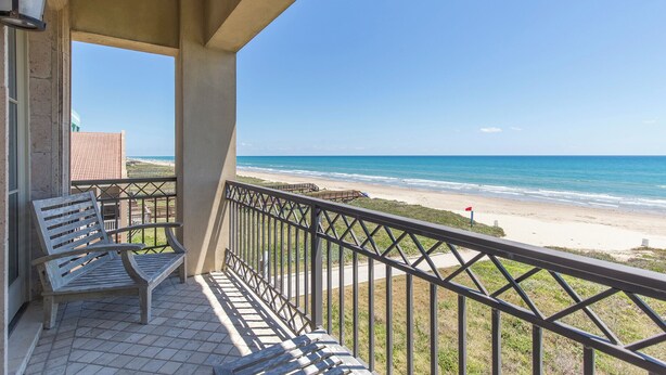 Een balkon met uitzicht op het strand en de oceaan.