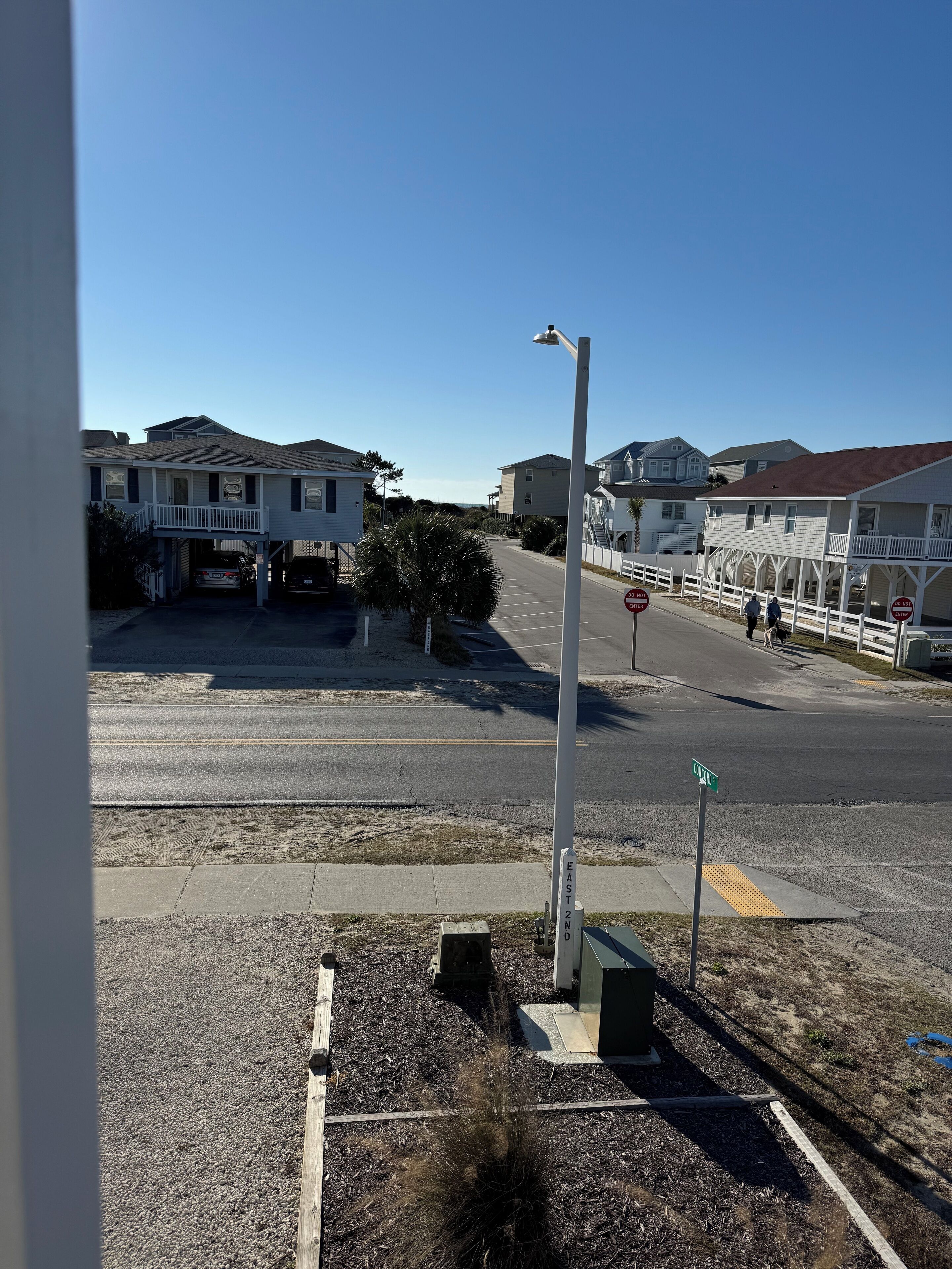 A street view with houses, a street lamp, and a sidewalk.