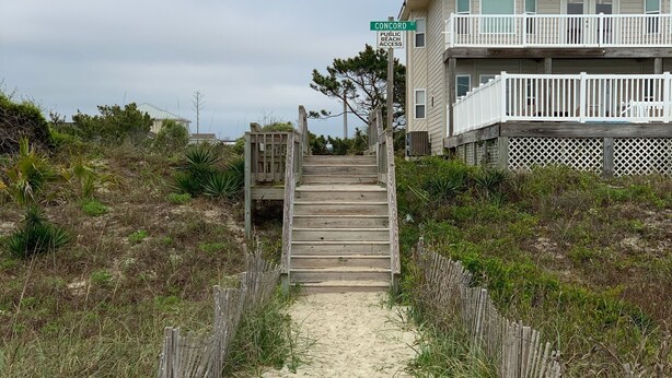 A wooden staircase leading to a beachfront property with a balcony. - Canal/w dock, pool, ocean view, 1 block from beach & EV charger (Ocean Isle Beach)