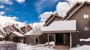 Un quartier résidentiel où de nombreuses maisons sont recouvertes de neige, avec des toits en pente et un ciel dégagé.