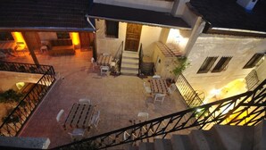 Un patio con mobiliario exterior, una escalera y la entrada de un edificio.