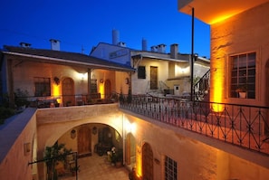 A hotel with a courtyard, outdoor seating, and a staircase leading to the upper floor. - Hotel Elvan (Ürgüp)