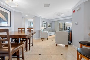 A spacious living area with a dining table, chairs, a sofa, and a TV.