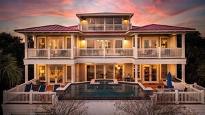 A two-story house with a pool, balconies, and a well-lit exterior. - Stay @ Sea Star on Isle of Palms (Isle of Palms)