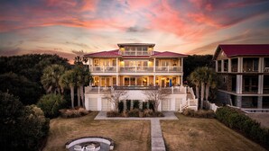 A large, two-story building with a balcony and a covered outdoor area, surrounded by greenery. - Stay @ Sea Star on Isle of Palms (Isle of Palms)